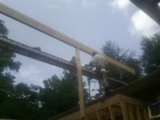 Carpenter setting a ridge beam over a new addition frame — Ice Dam Removal by Roofing Brothers in Westernport